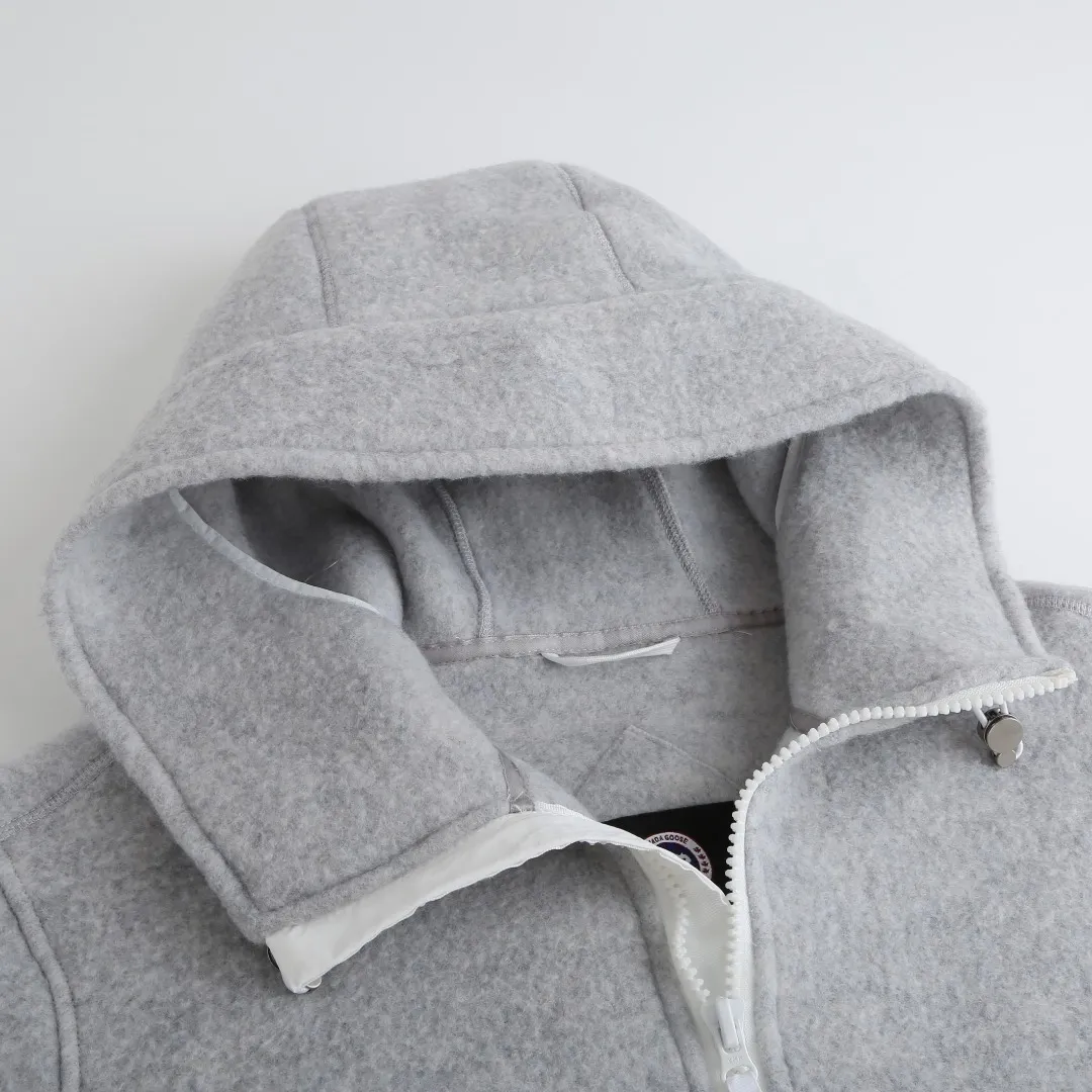 P770 Canada Goose Fleece Badge Hooded Jacket Fabric selection: Wool fleece fabric blended with wool as the main body and a very small amount of spandex and polyester fibers. Wool is a core natural ingredient that provides unparalleled temperature regulation, antibacterial and anti-odor properties and a skin-friendly feel. The feeding of a small amount of spandex gives the fabric a certain degree of four-way elasticity, making it non-restrictive during daily activities. As the basis of fleece's structure, polyester fiber enhances the fabric's durability, wrinkle resistance and quick-drying properties. It contributes to the loft of the fleece and provides functions such as trapping air.  Detail 1: The sleeves and hem are closed with 2×2 ribbing. Its strong elasticity can closely fit wrists and waists of different thicknesses, forming an effective 'seal' to prevent cold wind from blowing back. It can still maintain its original shape after repeated stretching and use, and is not easy to loose and deform. And the ribbed cuffs can convey a sense of design and enhance the visual beauty.  Detail 2: The combination of hood design and elastic buckle improves warmth and windproof performance when wearing.  Accessories: 1:1 customized elastic drawstring buckle, 1:1 customized zipper pendant, 1:1 customized armband SIZE: S M L XL hot new color